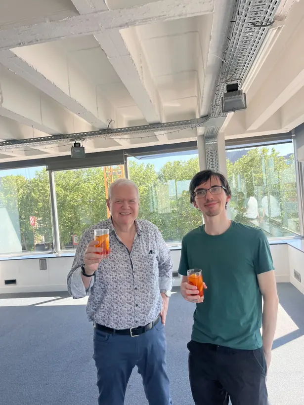 Twee collega's van Rollo heffen het glas op kantoor